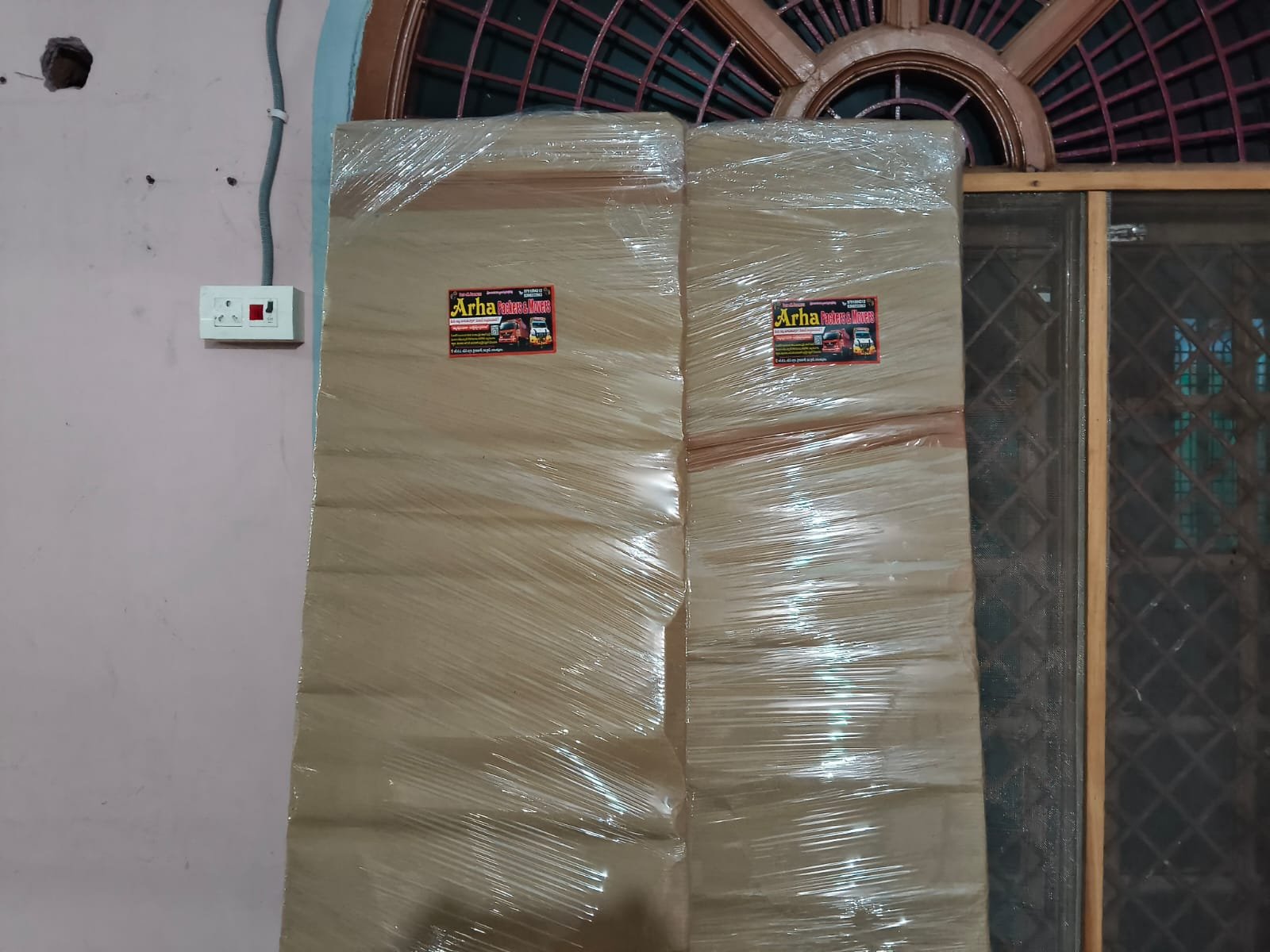 Wrapped household items placed against a wall