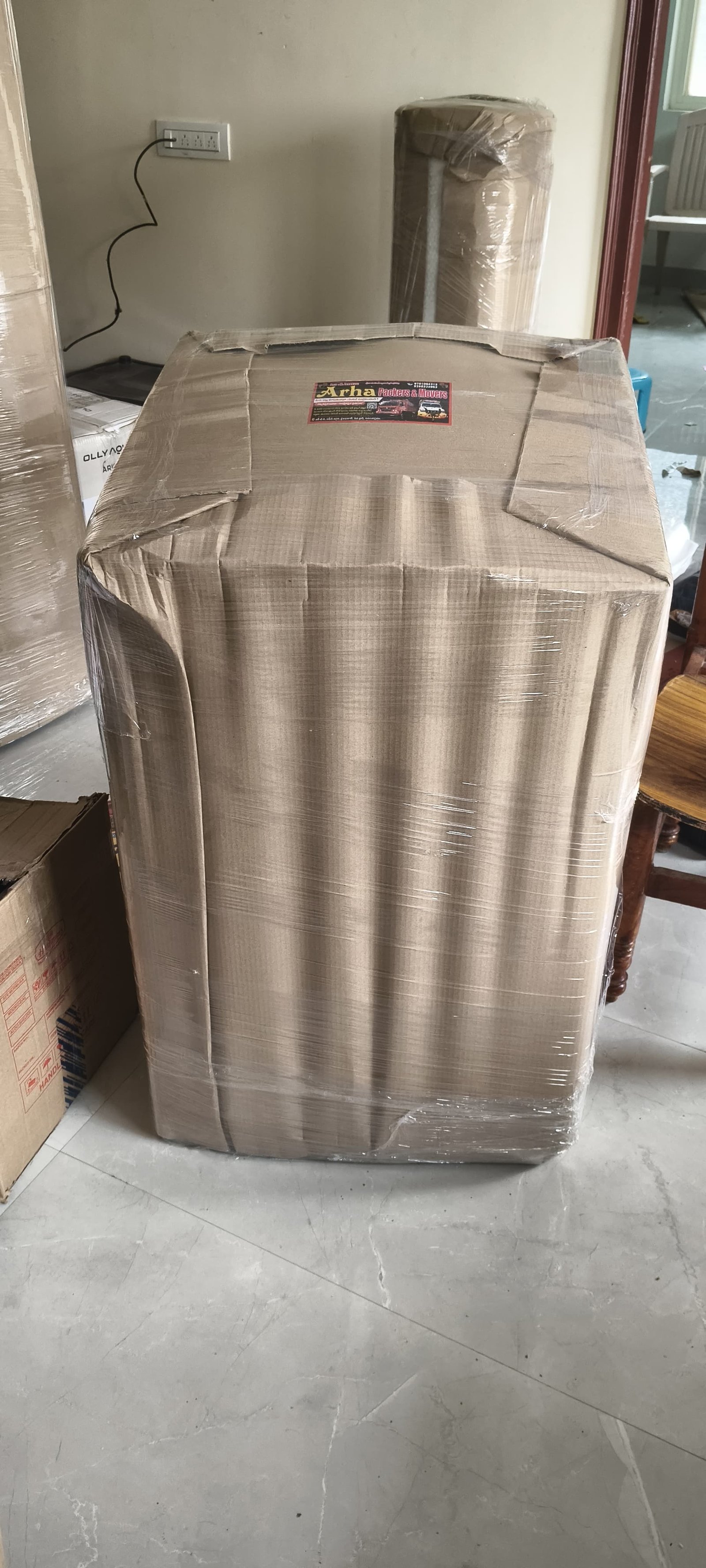 Large wrapped household item with ARHA Packers and Movers label